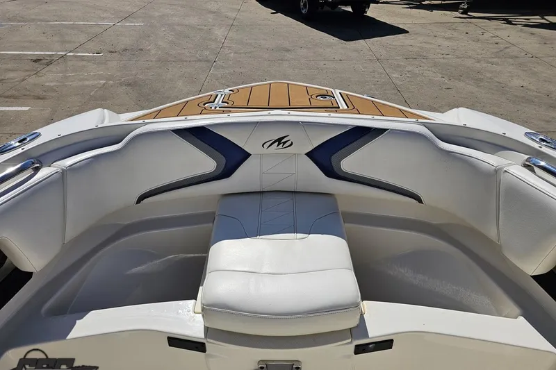 Slide: The Image of 2013 Monterey M3 Sport Boat interior with white and blue seating, docked on concrete. - 84