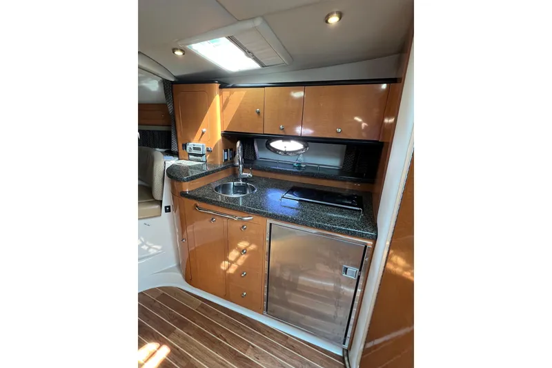 Slide: The Image of 2007 Chaparral Signature 330 yacht interior kitchen with wood cabinets and modern appliances. - 25