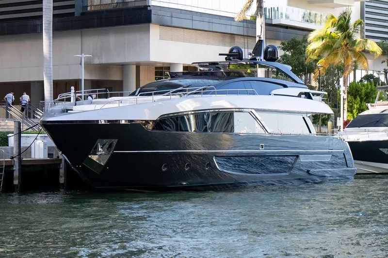 Slide: The Image of Luxury yacht Riva 100' Corsaro 2020 docked near modern building and palm trees. - 2