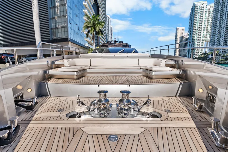 Slide: The Image of Luxurious 2020 Riva 100' Corsaro yacht deck with modern seating and cityscape backdrop. - 22