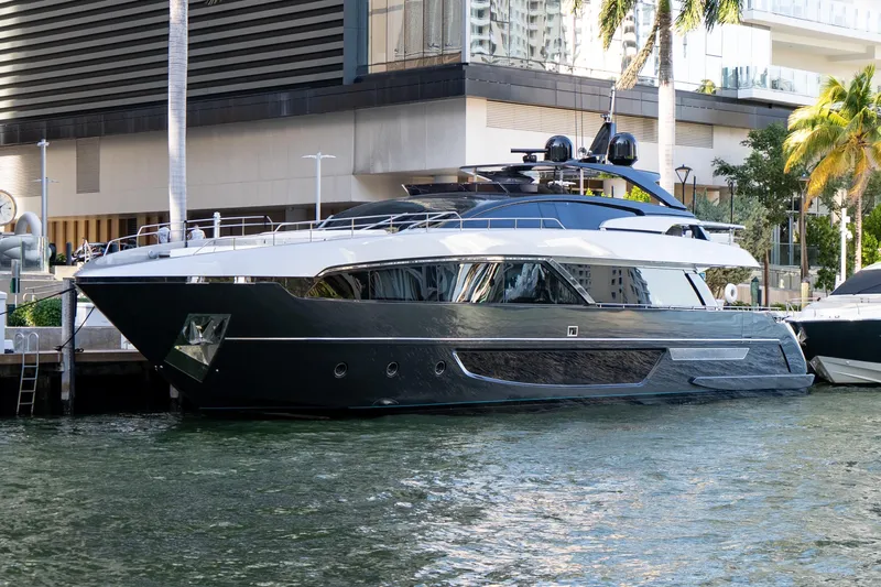 Slide: The Image of Luxury 2020 Riva 100' Corsaro yacht docked by modern waterfront buildings. - 4
