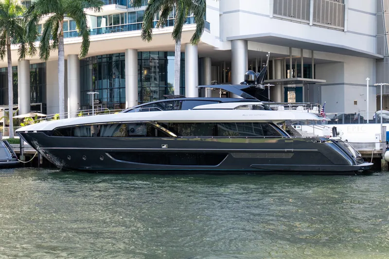 Slide: The Image of Luxury 2020 Riva 100' Corsaro yacht docked near modern waterfront building. - 5