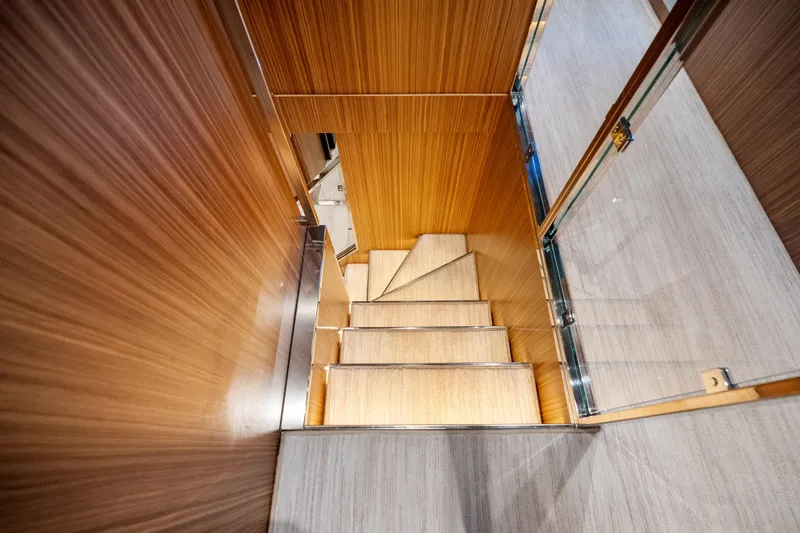 Slide: The Image of Luxurious wooden staircase inside 2020 Riva 100' Corsaro yacht, featuring elegant design. - 60