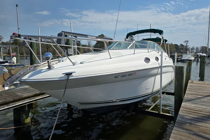 The Image of 2001 Sea Ray Sundancer 260 boat docked at a marina under a clear sky. - 1