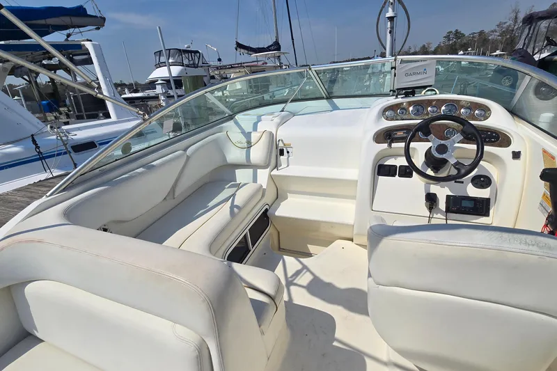 Slide: The Image of 2001 Sea Ray Sundancer 260 boat interior with steering wheel and seating at marina. - 10