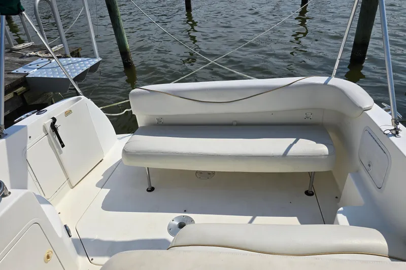 Slide: The Image of 2001 Sea Ray Sundancer 260 boat interior with white seating and dock view. - 11