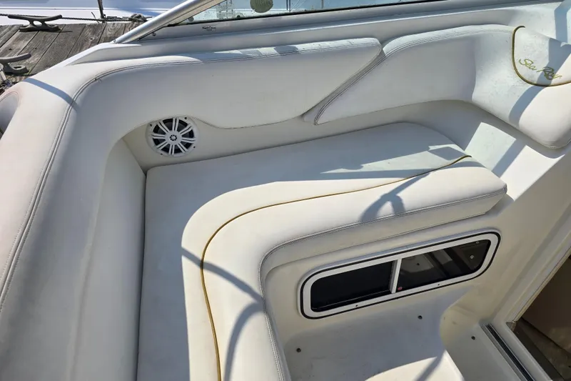 Slide: The Image of Interior seating of a 2001 Sea Ray Sundancer 260 boat, featuring white upholstery and speaker. - 18