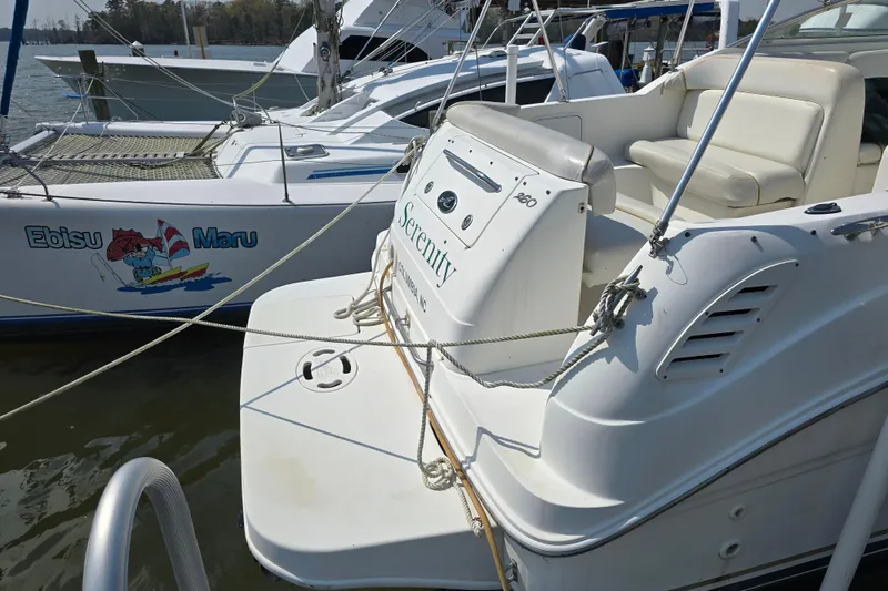 Slide: The Image of 2001 Sea Ray Sundancer 260 docked beside another boat, featuring a spacious seating area. - 20