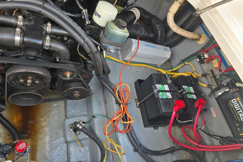 Slide: The Image of Engine compartment of a 2001 Sea Ray Sundancer 260 with visible wiring and battery setup. - 23