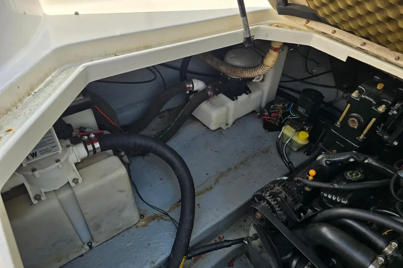 Slide: The Image of Engine compartment of a 2001 Sea Ray Sundancer 260 boat, showing mechanical components and hoses. - 24