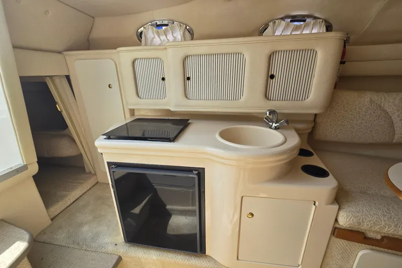 Slide: The Image of Interior of 2001 Sea Ray Sundancer 260 boat with kitchenette and seating area. - 26