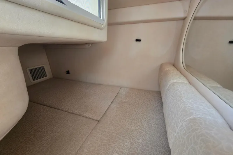 Slide: The Image of Interior cabin of 2001 Sea Ray Sundancer 260, featuring beige upholstery and a window. - 31