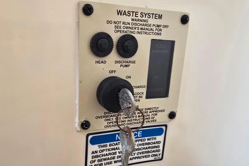 Slide: The Image of Control panel of 2001 Sea Ray Sundancer 260 waste system with discharge pump instructions. - 33