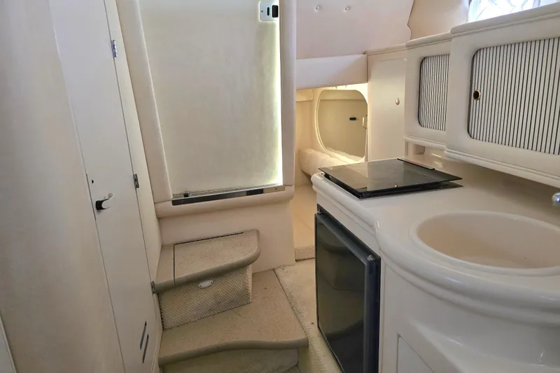 Slide: The Image of Interior of 2001 Sea Ray Sundancer 260, featuring kitchenette and cozy cabin space. - 38