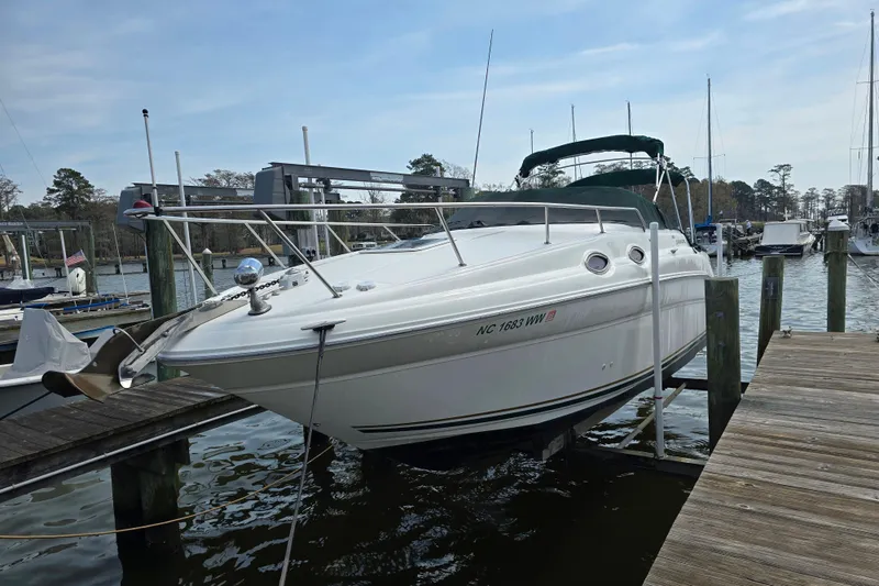 Slide: The Image of 2001 Sea Ray Sundancer 260 docked at marina, side view with green canopy. - 6