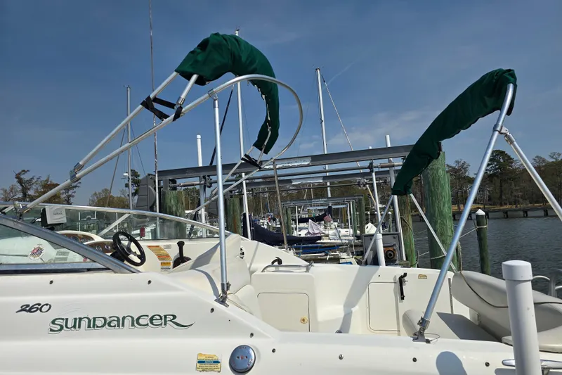 Slide: The Image of 2001 Sea Ray Sundancer 260 boat docked at marina, featuring green canopy and steering wheel. - 8