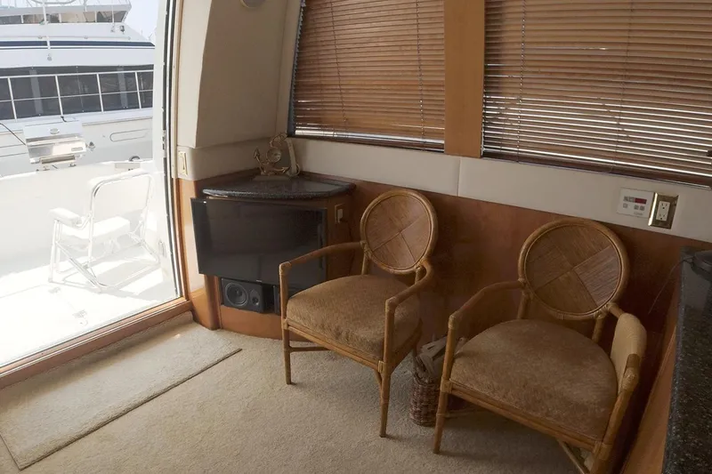Slide: The Image of Interior of 1999 Carver 53 Voyager yacht with wicker chairs and window view. - 10
