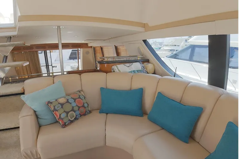 Slide: The Image of Interior of 1999 Carver 53 Voyager yacht with beige seating and blue cushions. - 11