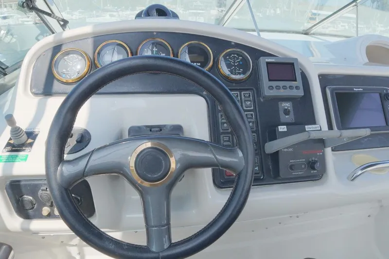 Slide: The Image of 1999 Carver 53 Voyager helm with steering wheel and navigation controls. - 17