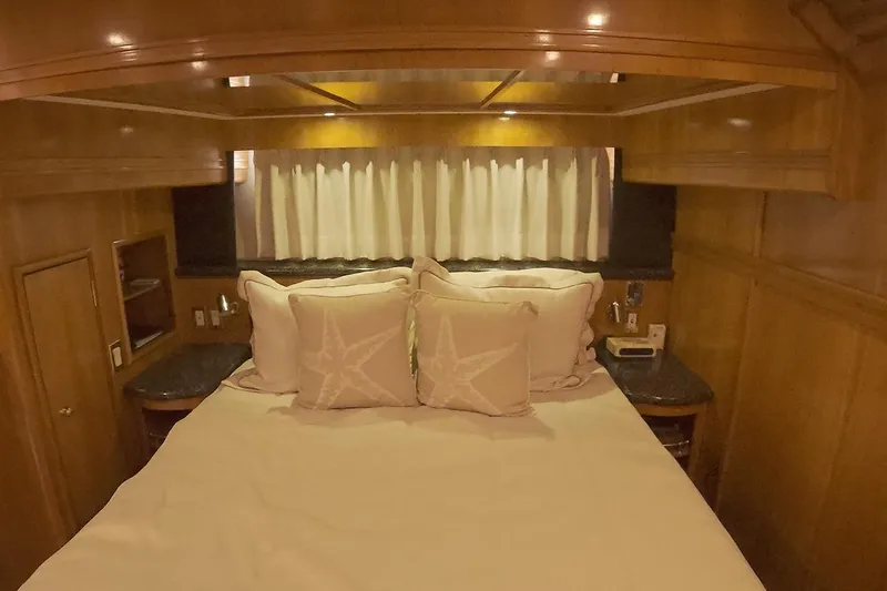 Slide: The Image of Cozy bedroom interior of 1999 Carver 53 Voyager yacht with wood paneling and starfish pillows. - 24
