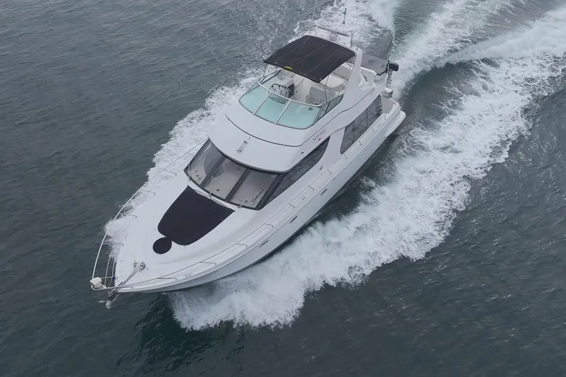 Slide: The Image of 1999 Carver 53 Voyager yacht cruising on open water, aerial view. - 3