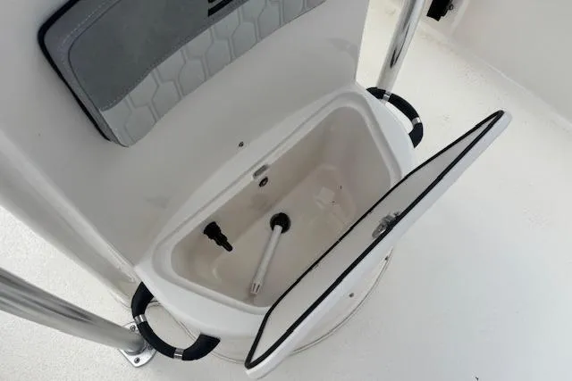Slide: The Image of 2024 Carolina Skiff 25 LS boat storage compartment with open lid and interior view. - 20