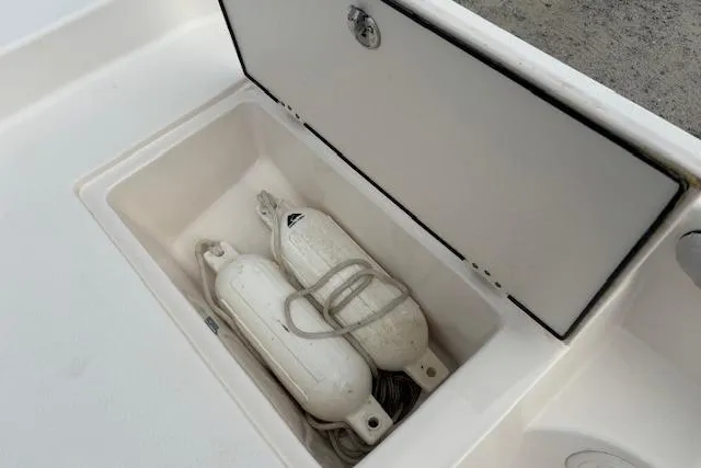 Slide: The Image of Storage compartment with boat fenders on a 2024 Carolina Skiff 25 LS. - 24