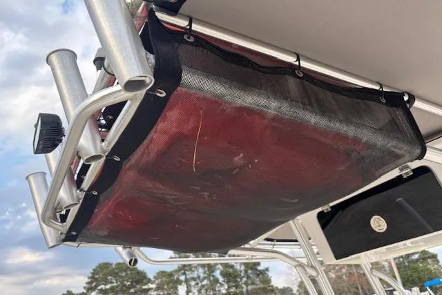 Slide: The Image of 2024 Carolina Skiff 25 LS boat with rod holders and storage netting under canopy. - 29