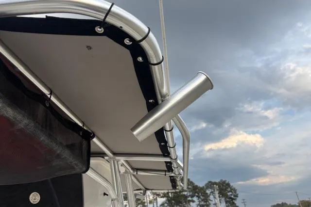 Slide: The Image of 2024 Carolina Skiff 25 LS boat canopy with rod holder against cloudy sky. - 30