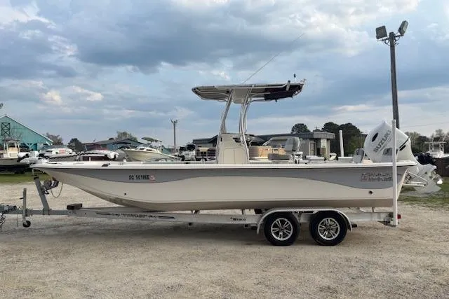 Slide: The Image of 2024 Carolina Skiff 25 LS boat on trailer, parked outdoors under cloudy sky. - 4