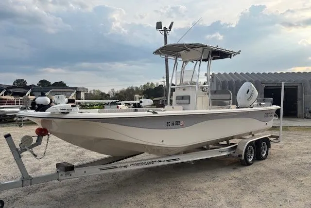Slide: The Image of 2024 Carolina Skiff 25 LS boat on trailer, parked outdoors under cloudy sky. - 5