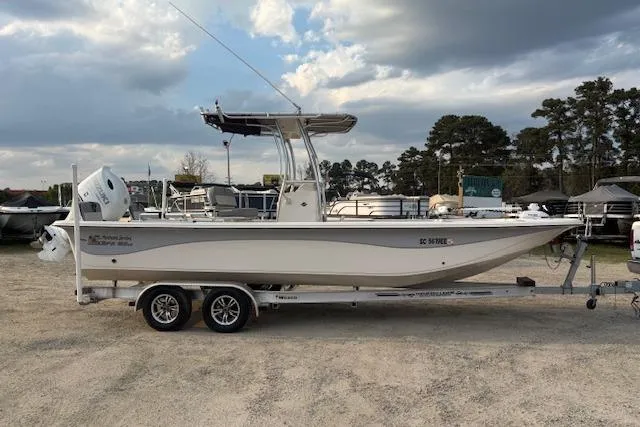Slide: The Image of 2024 Carolina Skiff 25 LS boat on trailer, parked outdoors under cloudy sky. - 8