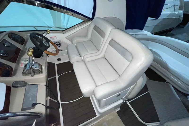 Slide: The Image of 2002 Sea Ray Sundancer 320 cockpit with dual white leather seats and steering console. - 11
