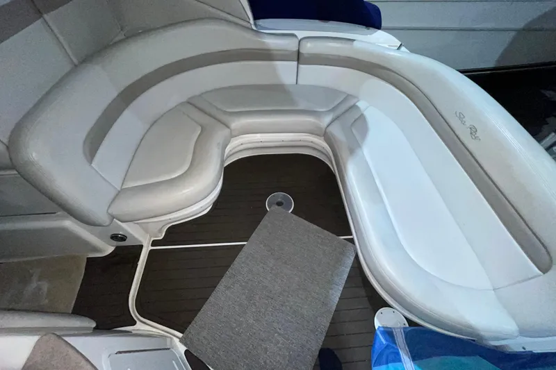 Slide: The Image of Interior seating of a 2002 Sea Ray Sundancer 320 boat, featuring curved white upholstery. - 14