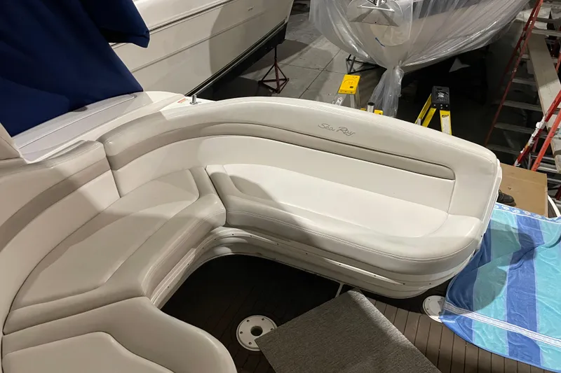 Slide: The Image of 2002 Sea Ray Sundancer 320 boat interior with white seating and blue towel. - 15