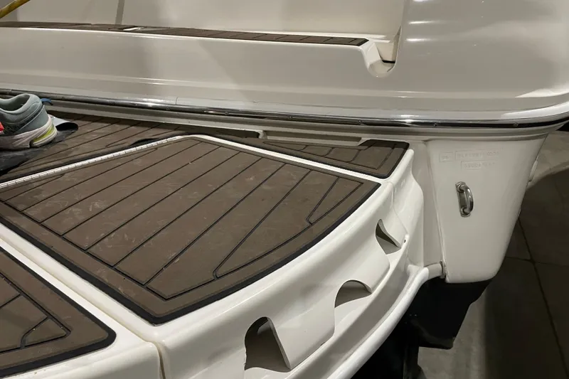 Slide: The Image of 2002 Sea Ray Sundancer 320 swim platform with teak-style decking and a shoe placed on it. - 2