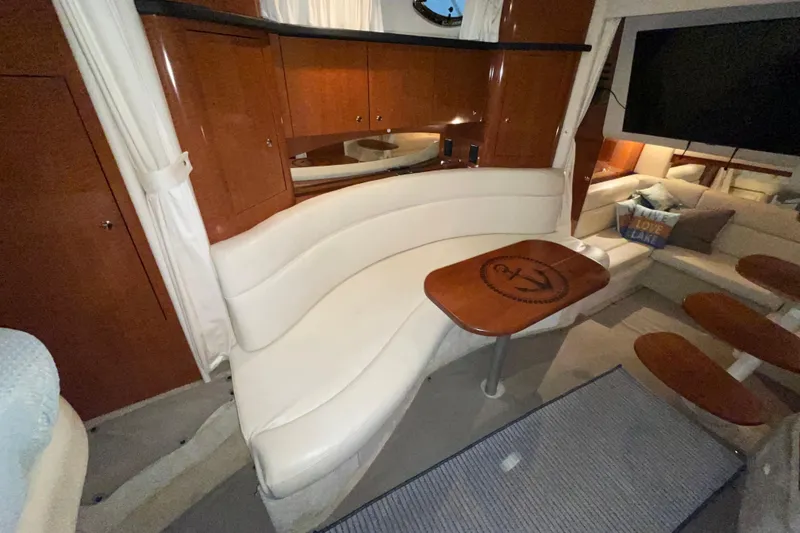 Slide: The Image of Interior of 2002 Sea Ray Sundancer 320 yacht with elegant seating and wooden table. - 23