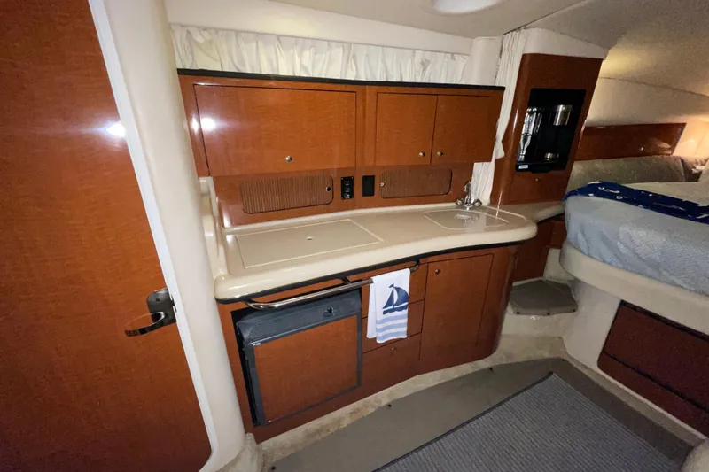 Slide: The Image of 2002 Sea Ray Sundancer 320 cabin interior with kitchenette and wood cabinetry. - 25