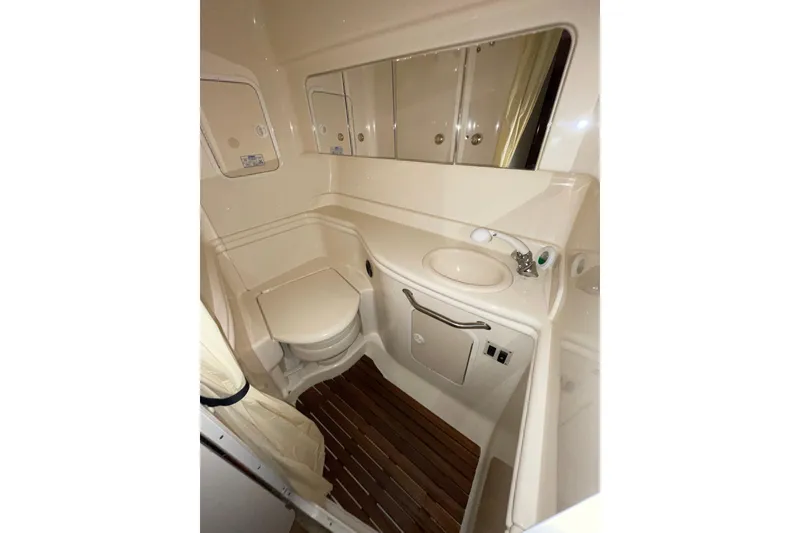Slide: The Image of 2002 Sea Ray Sundancer 320 bathroom with toilet, sink, and wooden floor. - 27