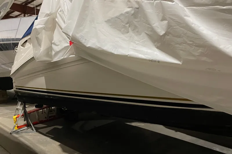 Slide: The Image of 2002 Sea Ray Sundancer 320 boat stored indoors, partially covered with protective tarp. - 30