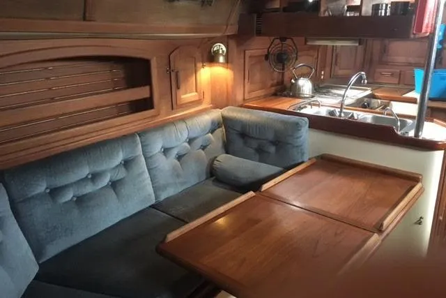 Slide: The Image of Interior of 1989 Pacific Seacraft 37 sailboat, featuring wooden cabinetry and compact kitchen area. - 21