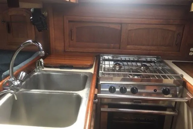Slide: The Image of 1989 Pacific Seacraft 37 yacht kitchen with dual sinks and stainless steel stove. - 22