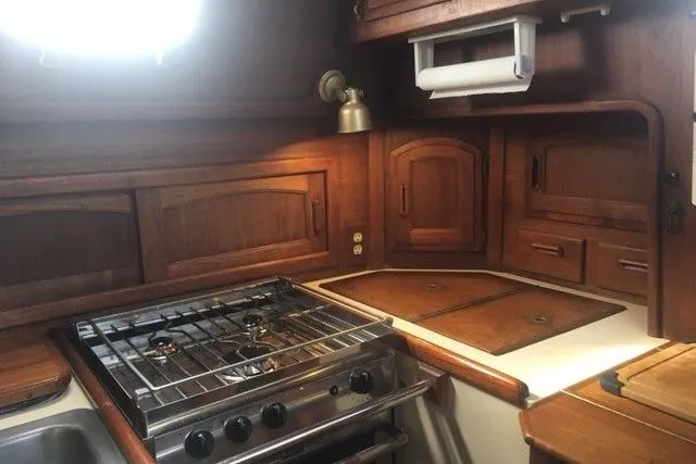 Slide: The Image of 1989 Pacific Seacraft 37 yacht kitchen with wooden cabinets and stainless steel stove. - 24