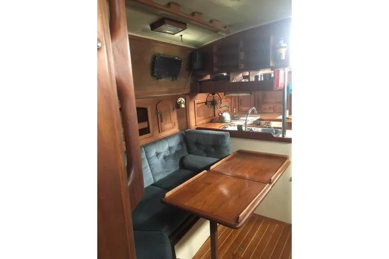 Slide: The Image of Cozy interior of 1989 Pacific Seacraft 37 sailboat with plush seating and wooden table. - 28
