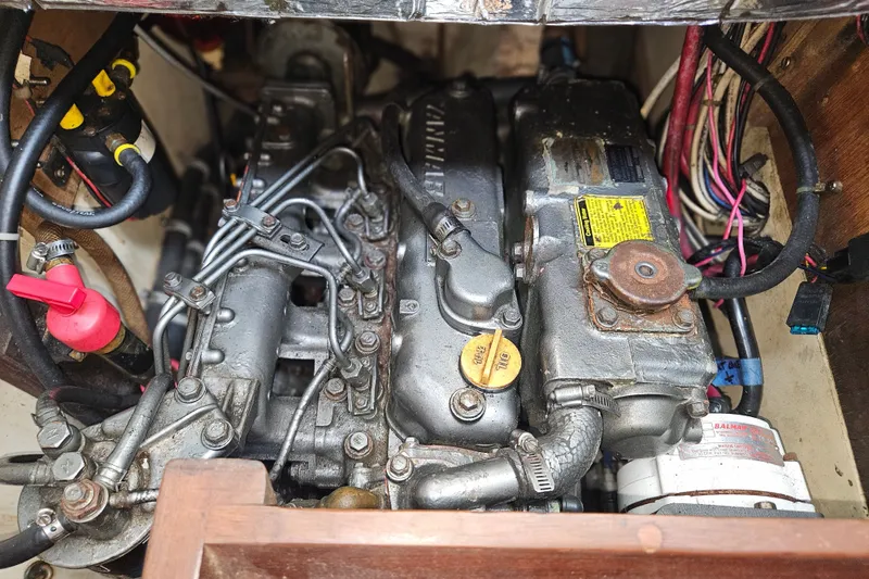 Slide: The Image of The engine compartment of a 1989 Pacific Seacraft 37 shows a well-maintained engine with various hoses and wires. - 39