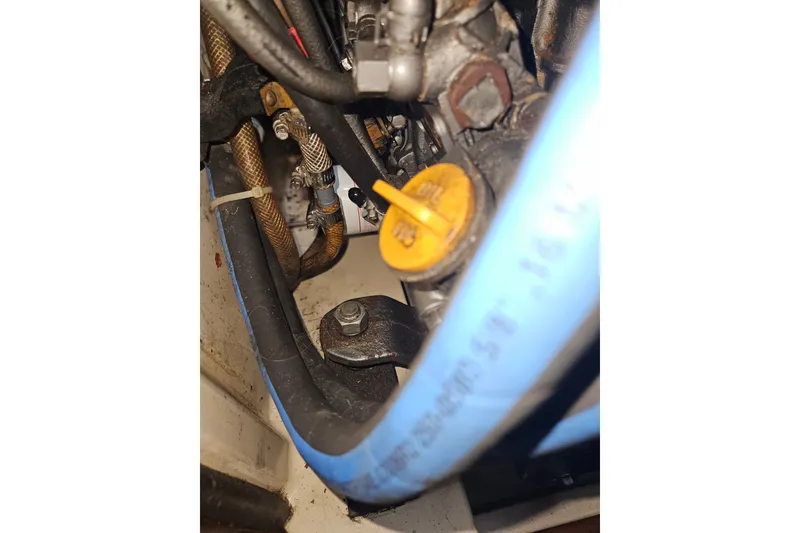 Slide: The Image of Engine compartment of a 1989 Pacific Seacraft 37 sailboat, featuring hoses and oil cap. - 41