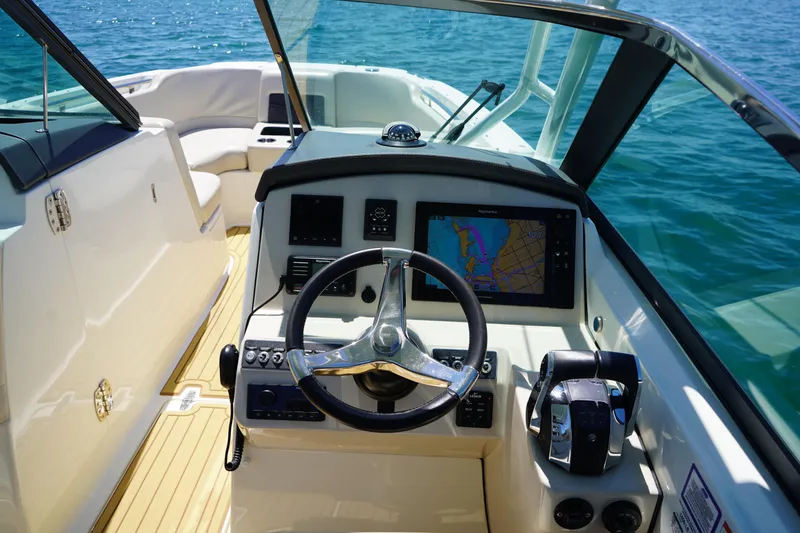 Slide: The Image of 2019 Boston Whaler 270 Vantage helm with navigation display on open water. - 12