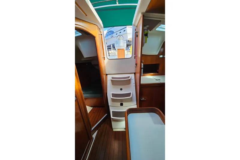Slide: The Image of Interior of 2000 Beneteau Oceanis Clipper 361 yacht with blue seating and wooden table. - 28