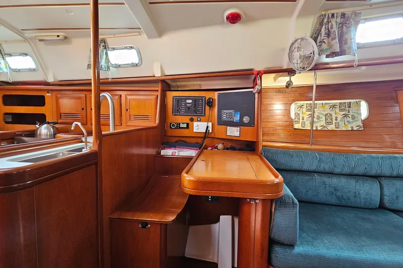 Slide: The Image of Interior of 2000 Beneteau Oceanis Clipper 361 yacht, featuring wood cabinetry and compact kitchen. - 30