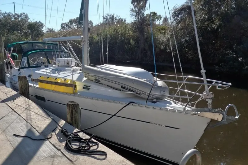 The Image of Beneteau Oceanis Clipper 361 sailboat docked, 2000 model, with lush greenery in the background. - 0